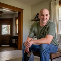 Marine veteran at home with family poses for portrait.